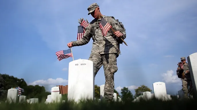 Members of the 3rd U.S. Infantry Regiment place American flags at the graves of U.S. soldiers buried in Section 60 at Arlington National Cemetery in preparation for Memorial Day May 24, 2012. (Credit: Win McNamee/Getty Images)